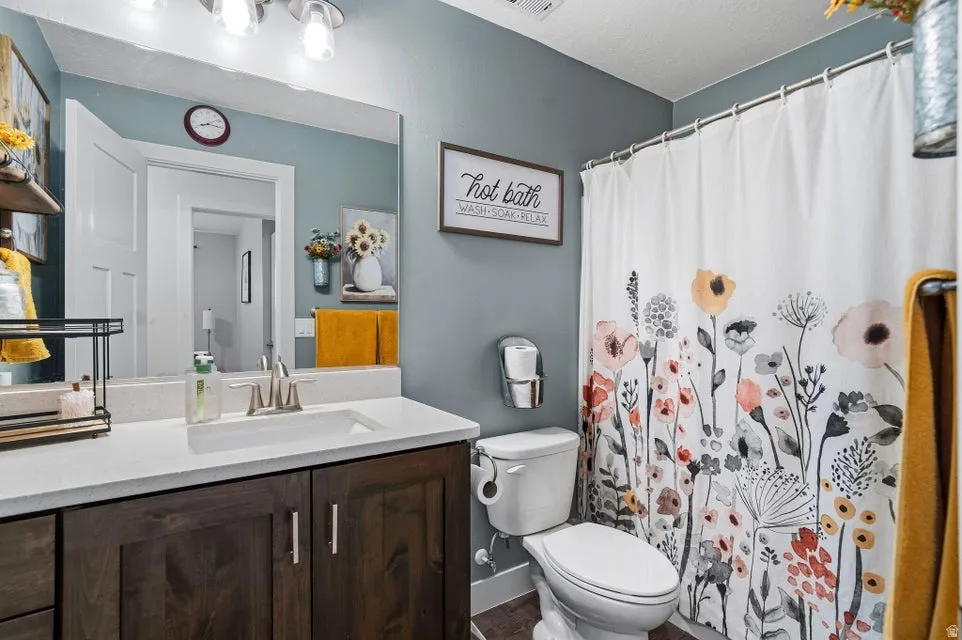 Full bathroom featuring a dark wood-finish vanity with a white countertop, chrome faucet, and a large wall-mounted mirror