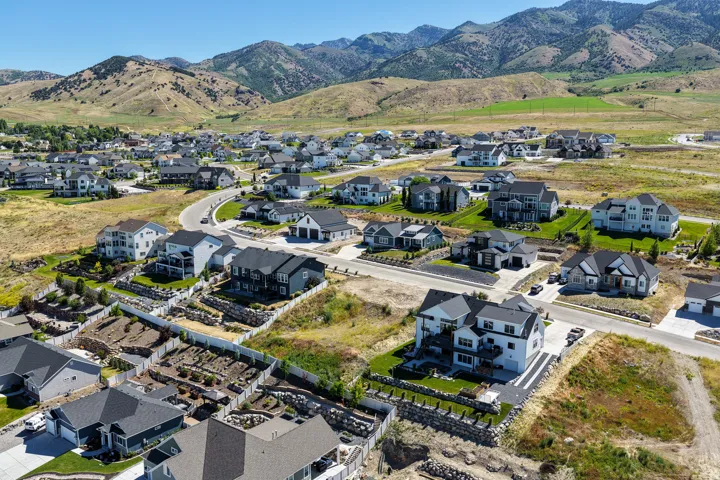 Sprawling residential development featuring diverse architectural styles, mountain backdrop, and varying lot sizes