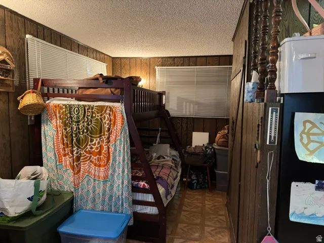 Room featuring wood paneling on walls, horizontal blinds, and patterned tile flooring