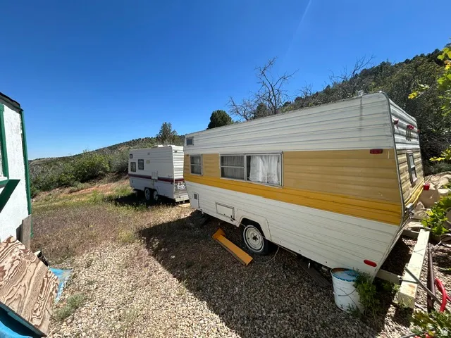 Gravel-covered terrain with two parked recreational vehicles