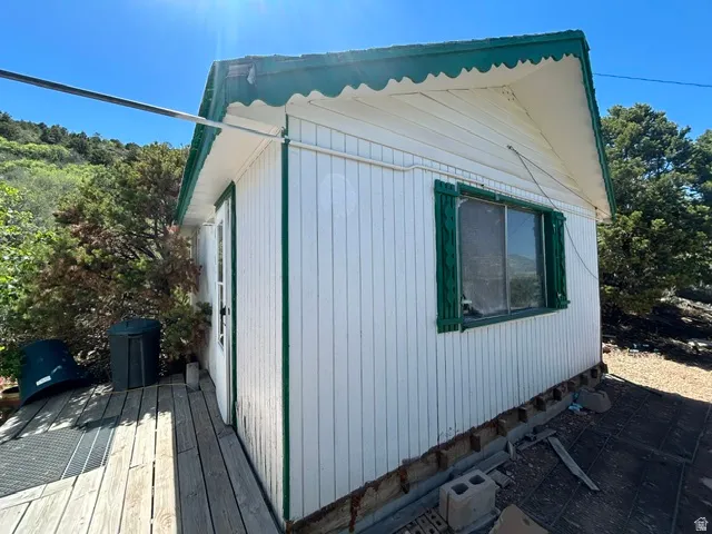 White vertical siding exterior with green trim and scalloped roofline
