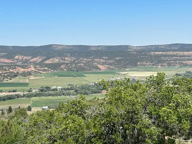 Expansive valley scenery featuring distant mountains and cultivated fields