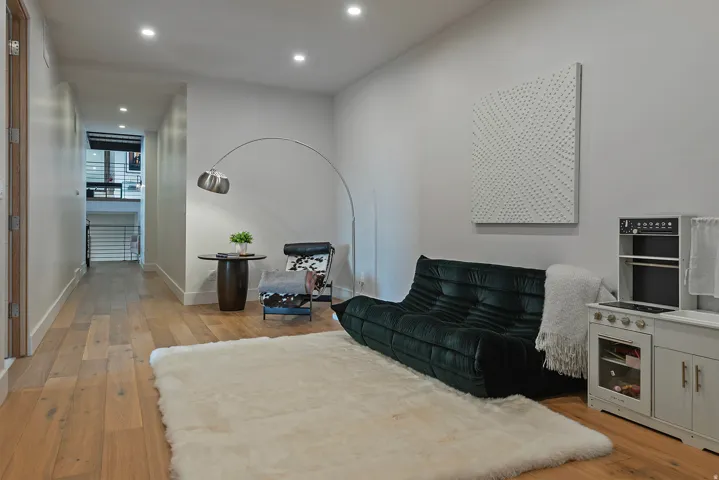 Wide plank wood-finish flooring extends through a bright interior space with recessed lighting