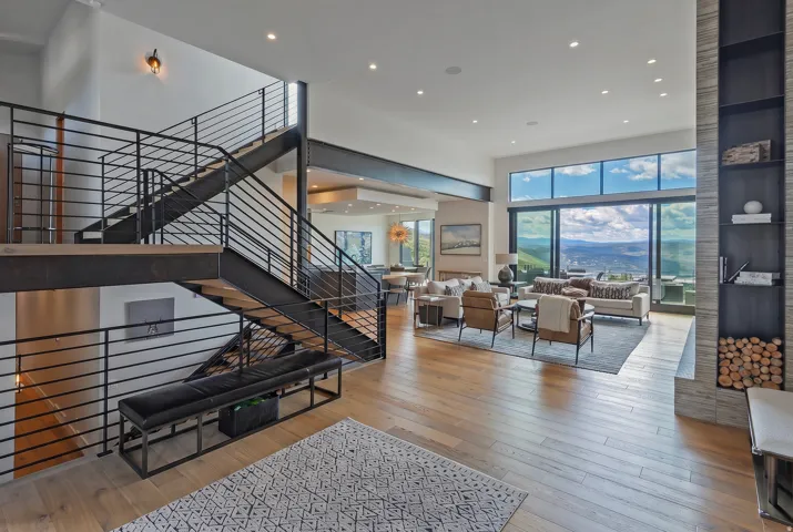 Contemporary interior with wood-finish flooring and a multi-level staircase featuring industrial-style metal railings