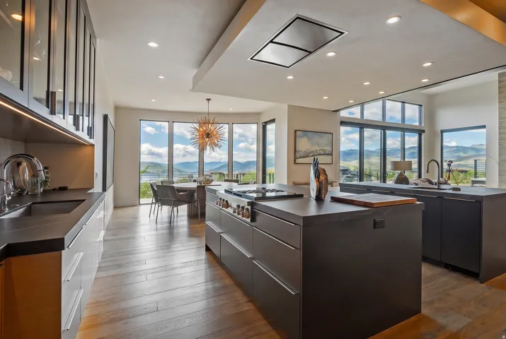 Modern kitchen featuring wood-finish flooring and extensive dark-toned flat-panel cabinetry