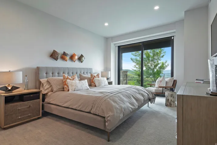 Spacious room with a large sliding glass door, recessed lighting, and light-toned carpeting