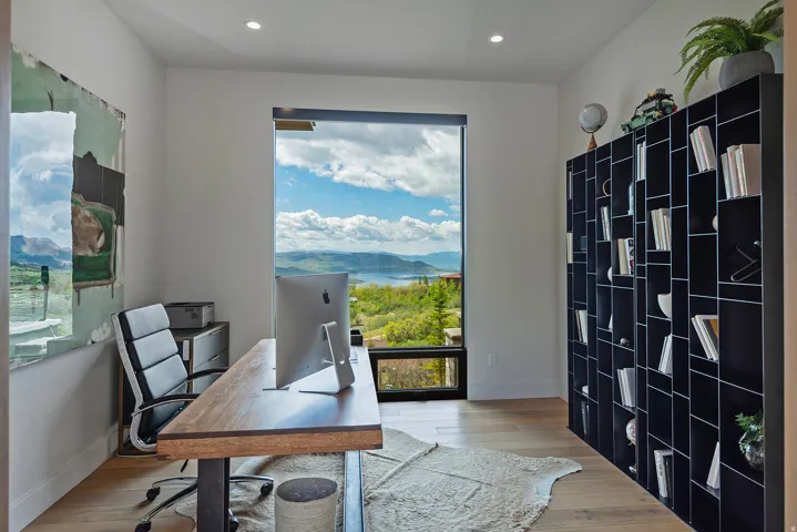 Expansive floor-to-ceiling window offering panoramic mountain and water scenery