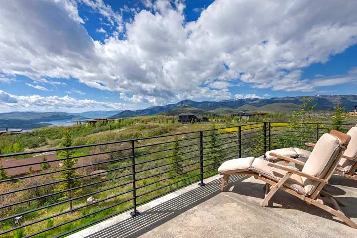 Spacious balcony featuring a concrete surface and black metal horizontal bar railing