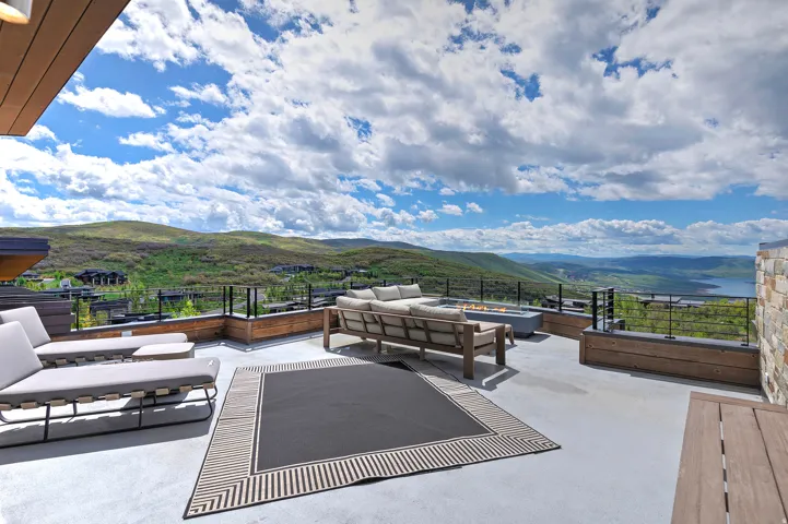 Expansive outdoor deck featuring a concrete surface and glass-panel railings