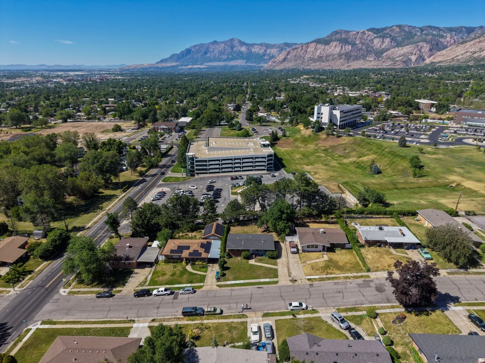Residential neighborhood featuring established homes with mature landscaping, surrounded by expansive green spaces