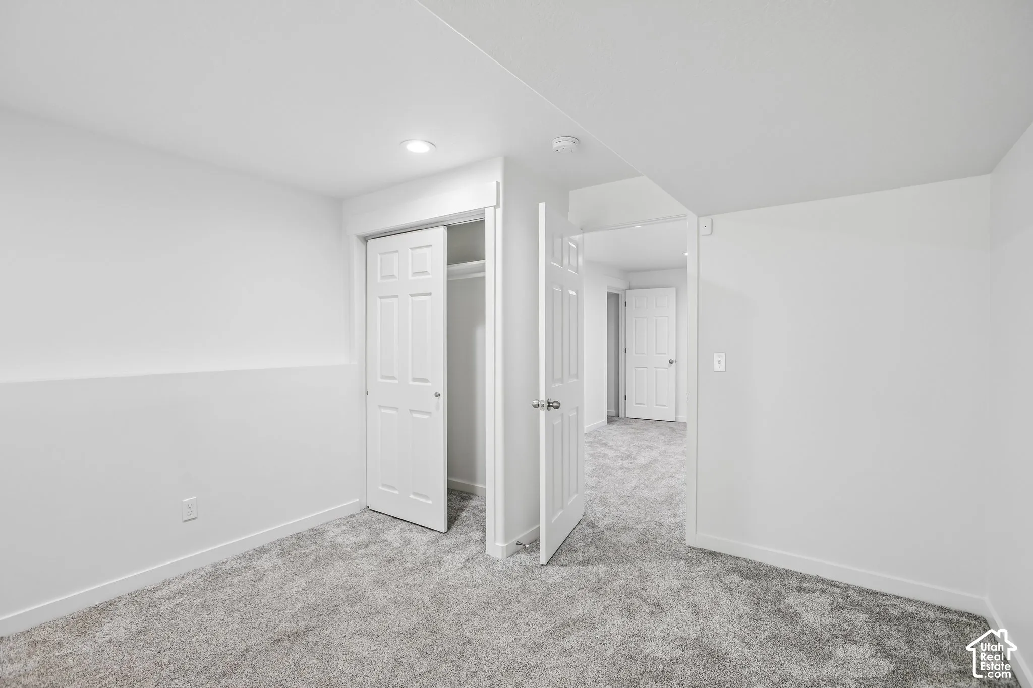 Neutral-toned carpeting and white walls create a bright interior