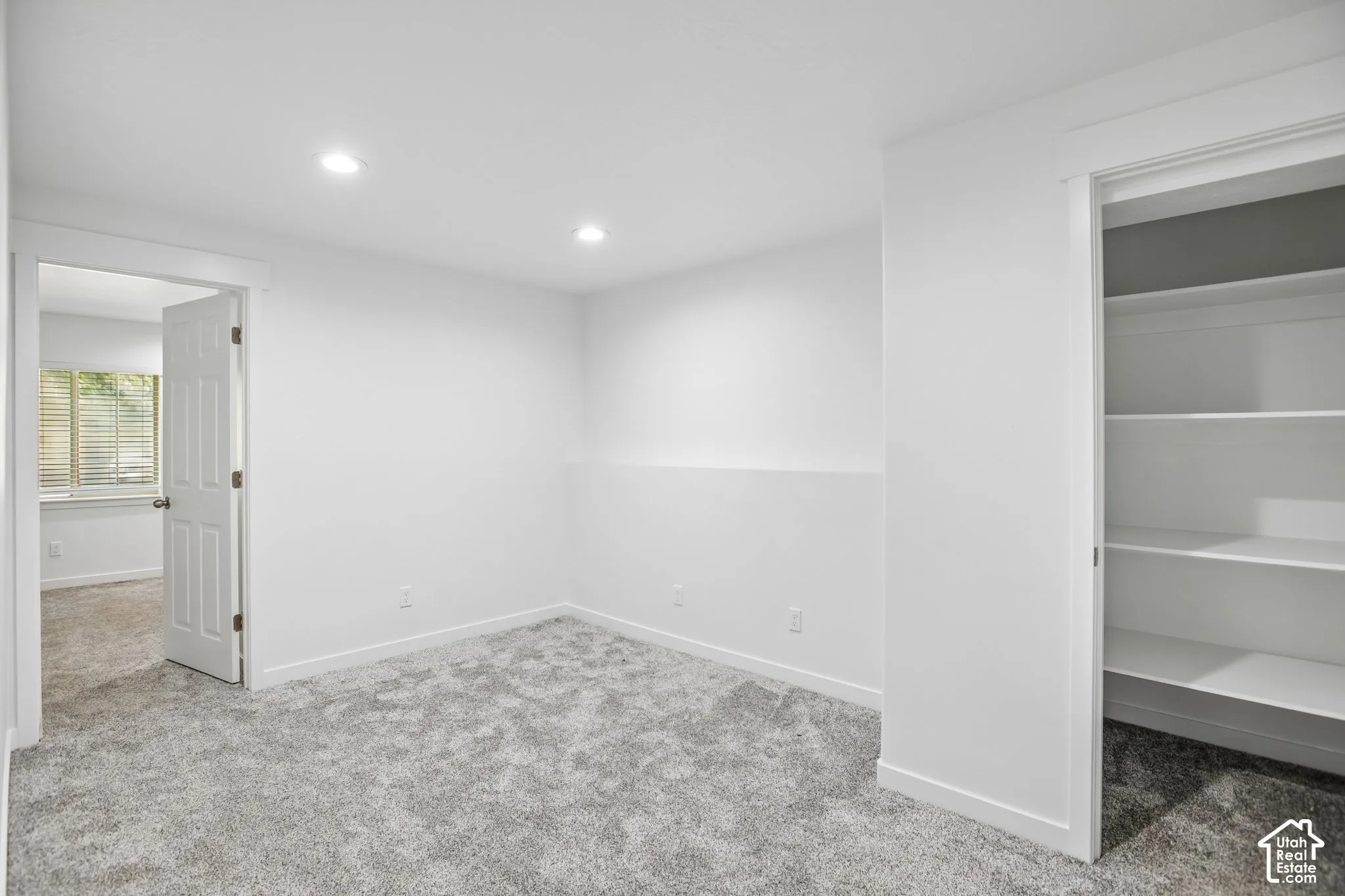 Neutral-toned room featuring plush carpeting and recessed ceiling lighting