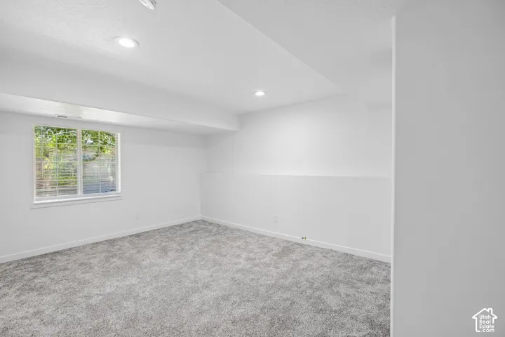 Bright room with recessed lighting and fresh gray carpeting