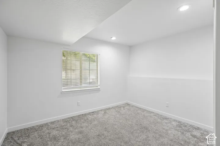 Room featuring neutral gray carpet, white walls, and recessed lighting