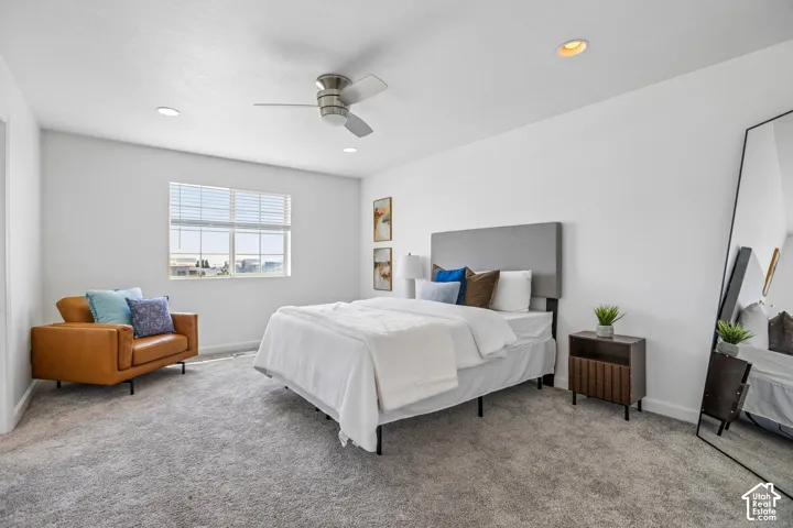 Spacious room featuring light gray carpet flooring, a window with blinds, a ceiling fan, and recessed lighting