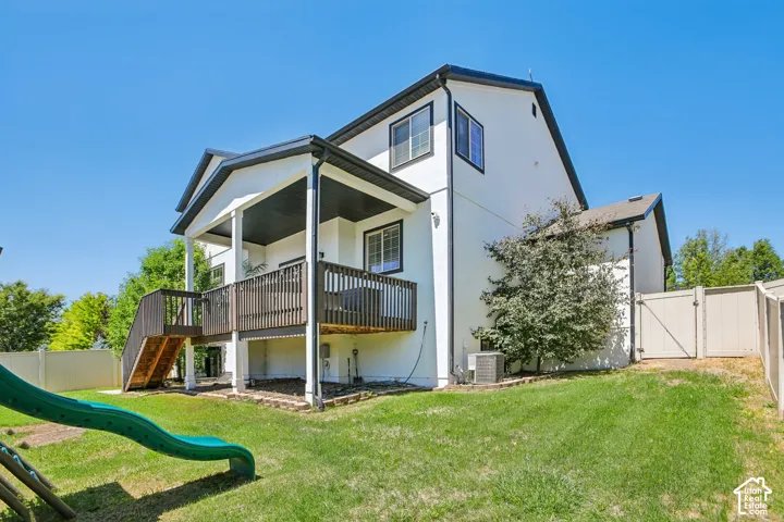 Spacious rear exterior featuring a two-story design with white siding and dark trim