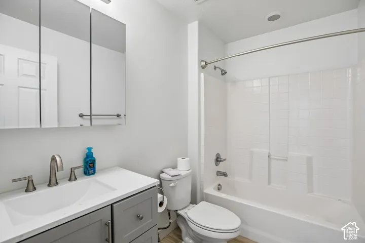 Bathroom featuring a single vanity with a white countertop and undermount sink, brushed nickel faucet, and a medicine cabinet with integrated lighting