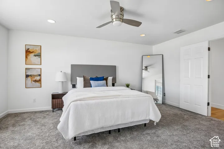 Spacious room featuring gray carpet, recessed lighting, and a ceiling fan