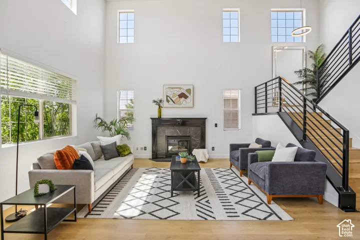High-ceiling living area featuring a dark stone-clad fireplace and wood-finish flooring