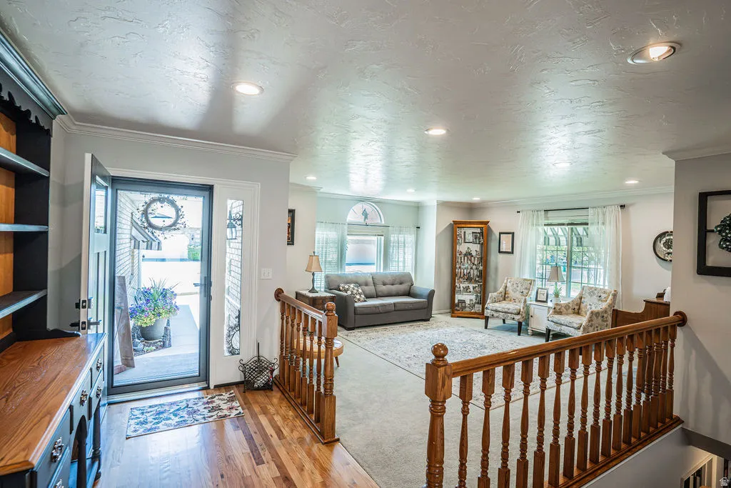 Entryway featuring wood-finish flooring, a built-in cabinetry unit, and a wooden baluster railing