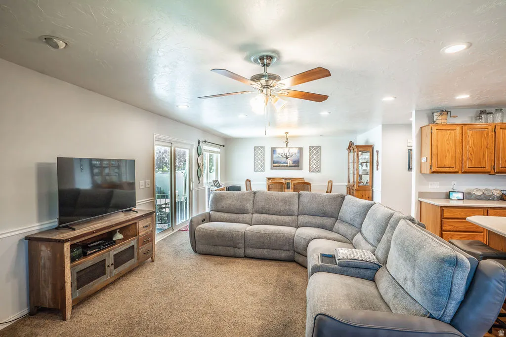 Open-concept living space with recessed lighting, ceiling fan, and carpet flooring