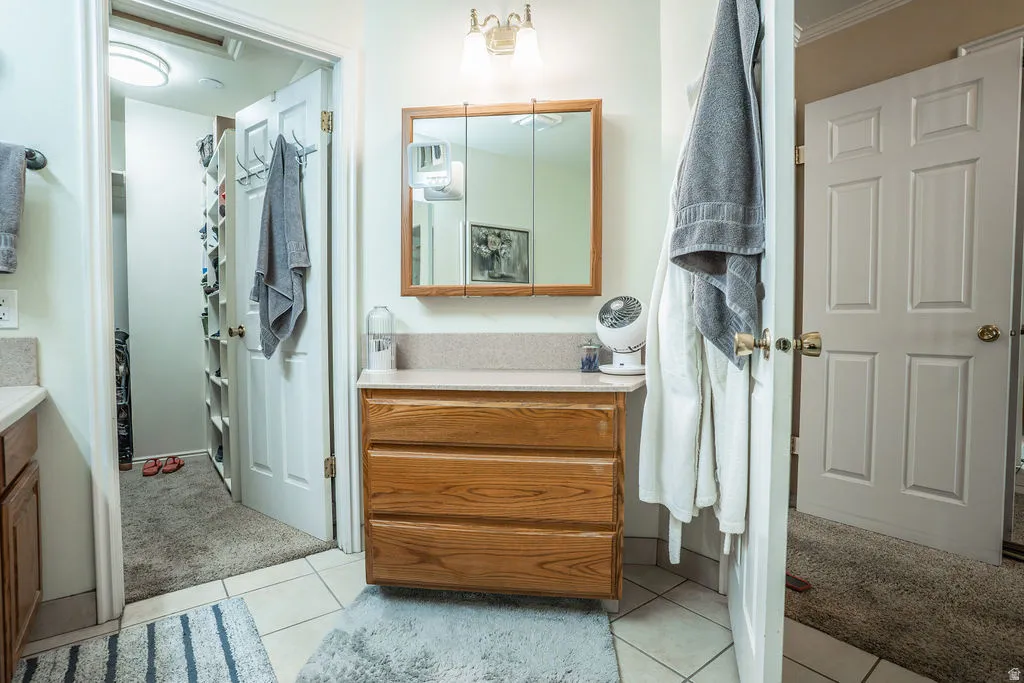 Bathroom vanity featuring a light wood-finish cabinet with three drawers, a light-colored countertop, and a mirrored medicine cabinet above