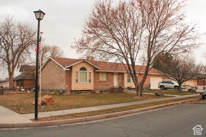 Brick exterior residence with a bay window, a light-colored entry door, and an attached two-car garage