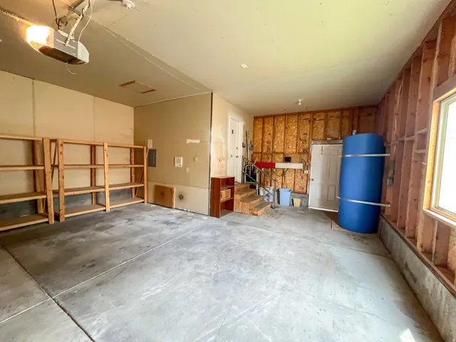 Spacious garage featuring concrete flooring and exposed wood framing