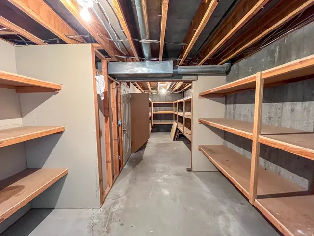 Unfinished basement featuring exposed wood ceiling joists and concrete flooring
