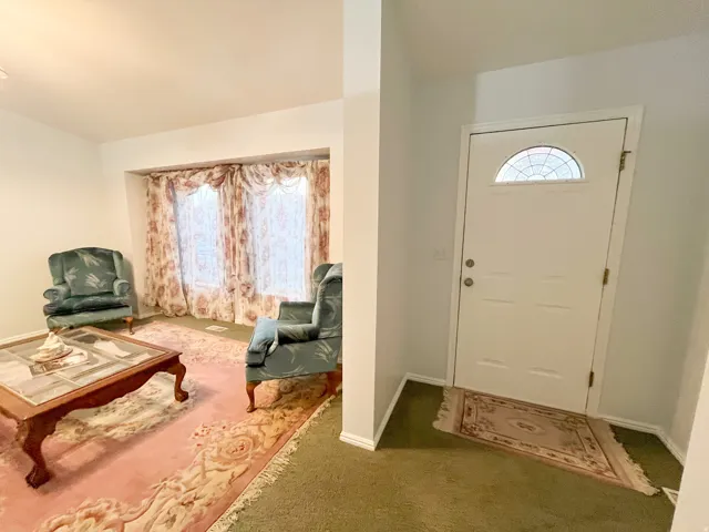 White entry door with an arched decorative glass insert and brass hardware