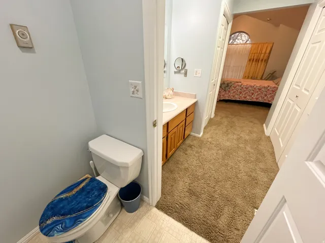Vanity with light wood-finish cabinetry and white countertop