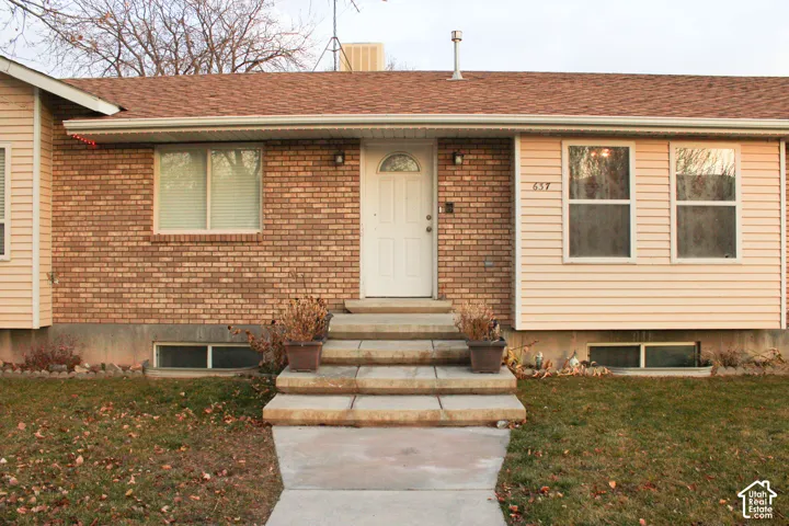 Brick and siding exterior featuring a central entry with a white door