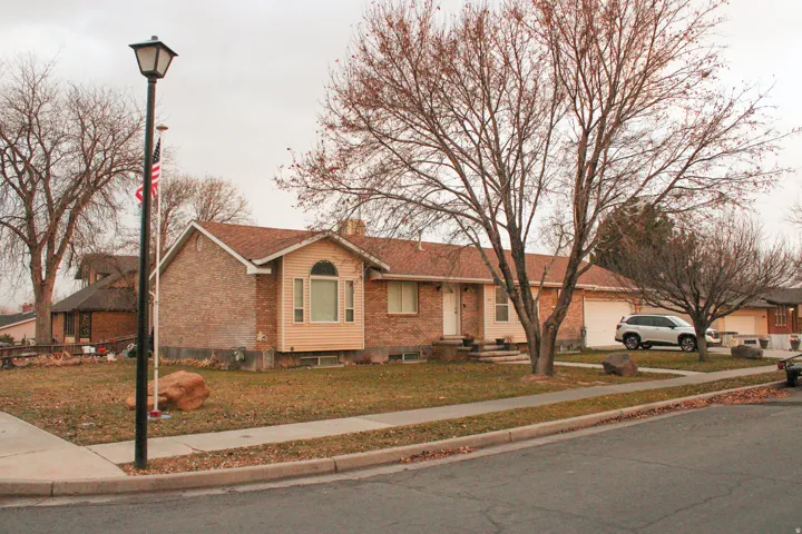 Brick exterior residence with a bay window, a light-colored entry door, and an attached two-car garage