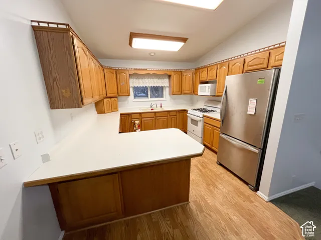 Kitchen featuring wood-finish cabinetry, white countertops, and wood-finish flooring