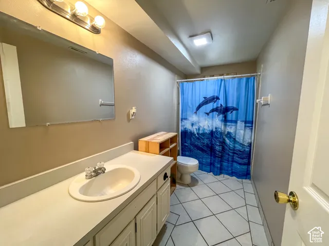 Bathroom featuring a vanity with an integrated sink, a rectangular wall mirror, and a three-light vanity fixture