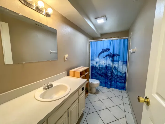 Bathroom featuring a vanity with an integrated sink, a rectangular wall mirror, and a three-light vanity fixture