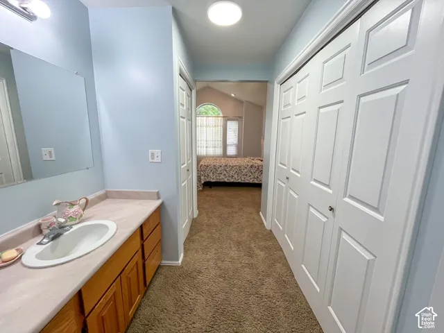 Bathroom vanity featuring a light-toned countertop, an integrated sink, and wood-finish cabinetry