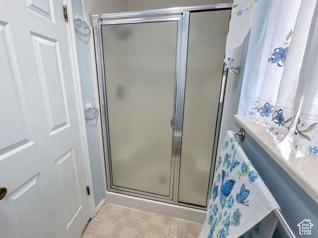 Enclosed shower with frosted glass panels and chrome framing