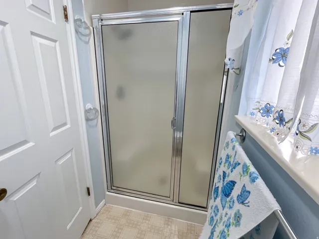 Enclosed shower with frosted glass panels and chrome framing