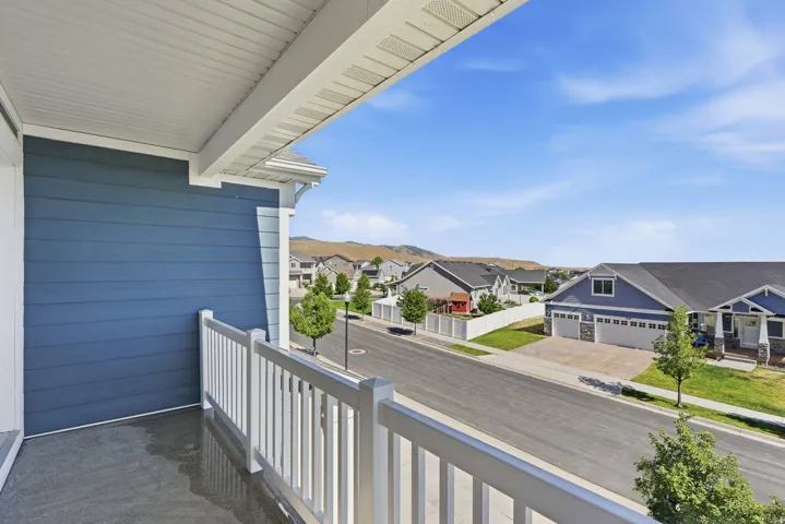 Private balcony with white railing, offering neighborhood scenery