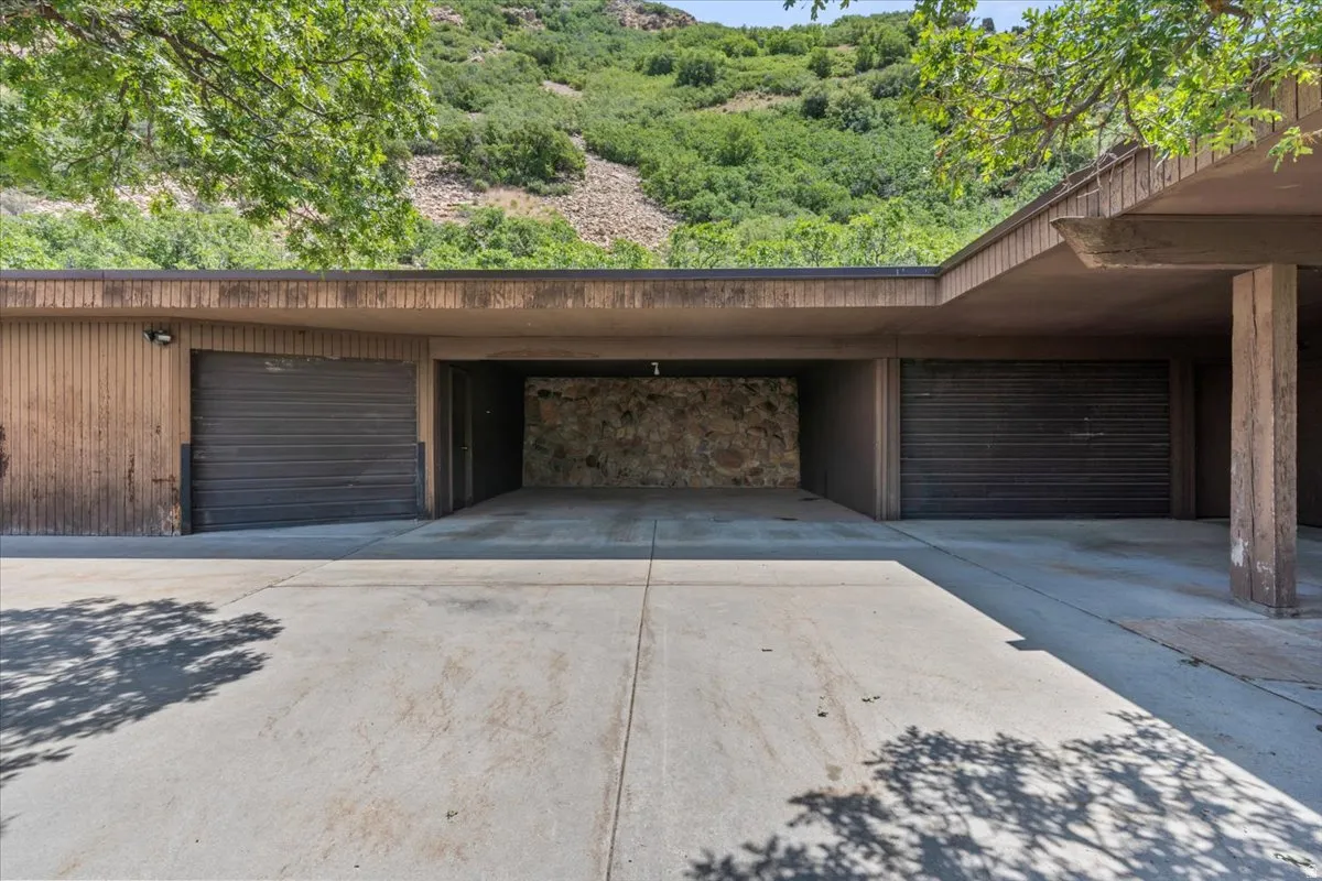 Expansive concrete driveway leading to a multi-bay garage structure