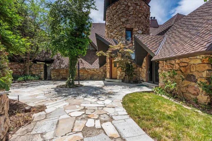 Stone-clad exterior featuring a prominent round tower and multi-level roofline