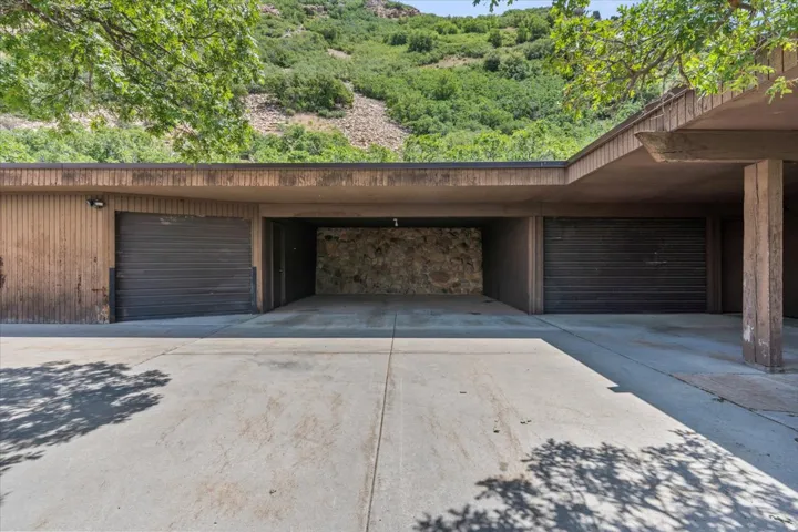 Expansive concrete driveway leading to a multi-bay garage structure