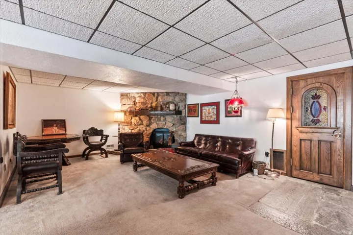 Spacious room featuring a stone-clad fireplace and hearth