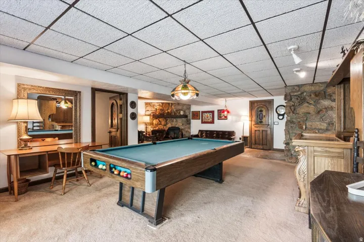 Recreational space featuring a pool table, stone accent wall, and built-in wood cabinetry
