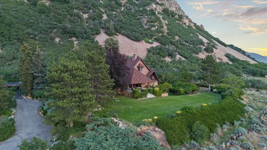 Terraced hillside property featuring a multi-story residence with a prominent gabled roofline and natural wood siding