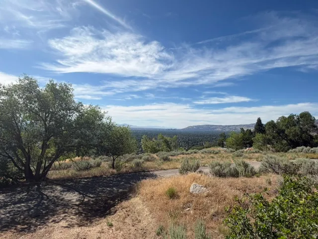 Expansive natural landscape featuring rolling hills and distant mountain ranges