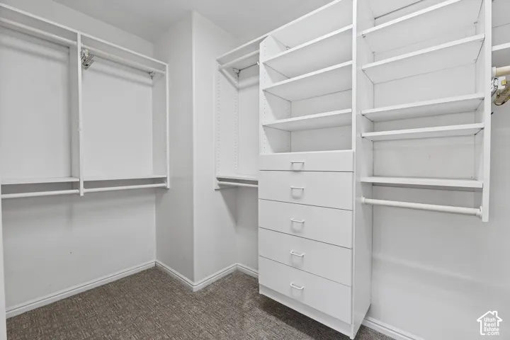Custom closet system featuring multiple hanging rods, built-in shelving, and drawers