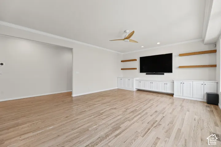 Hardwood flooring, crown molding, ceiling fan, recessed lighting, and built-in cabinetry with wood shelves