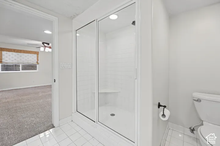 Primary Bathroom featuring a spacious walk-in shower with frameless glass enclosure and subway tile surround, ceramic tile flooring, toilet with chrome fixtures, and recessed ceiling lighting